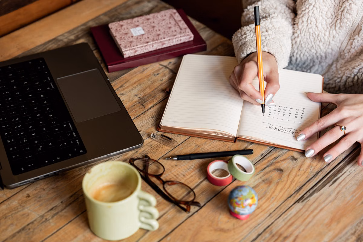 Person writing wellness notes in a personal journal